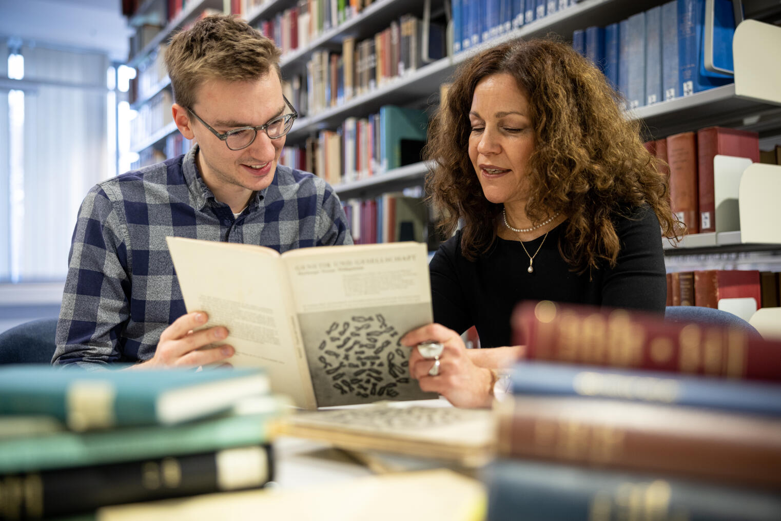 Bild von Isabel Heinemann und Lukas Alex in einer Bibliothek